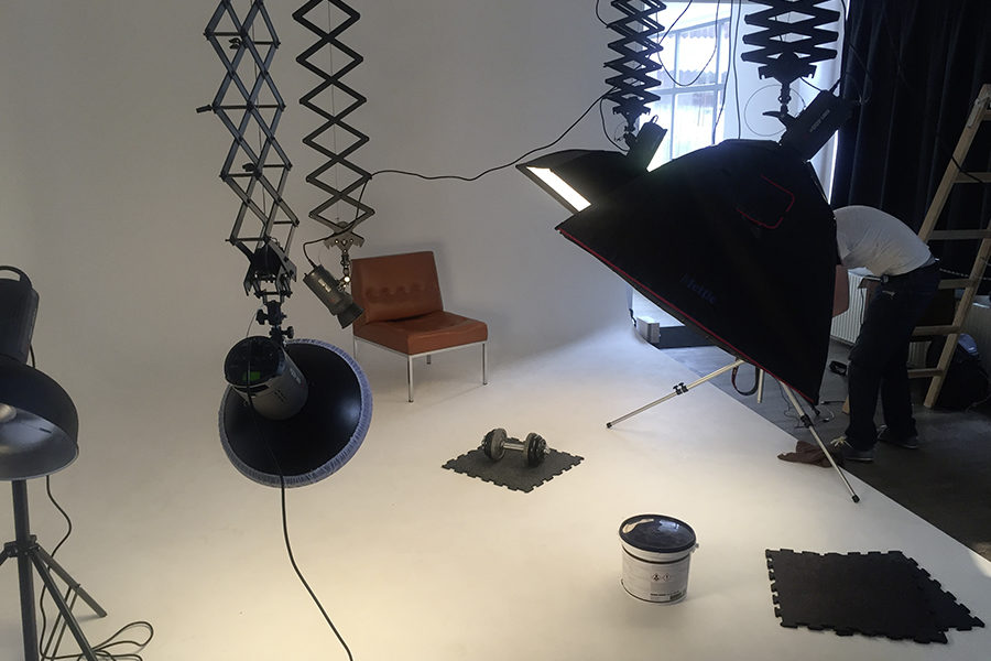 Hier sieht man einen Fotograf in einem Foto- Studio beim fotografieren von PVC Bodenplatten