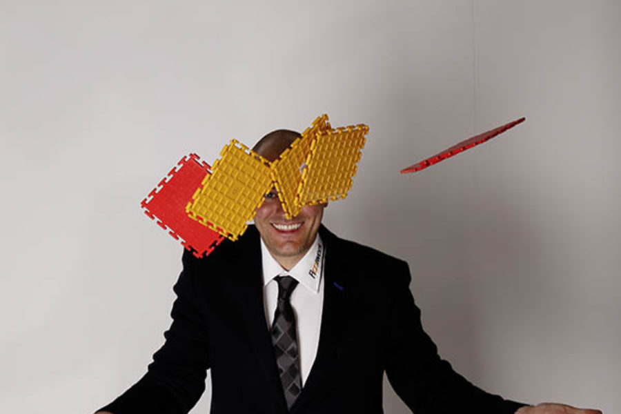 Der CEO von FLOORWORK wirft kleine PVC Bodenfliesen für einen Garagenboden in die Luft