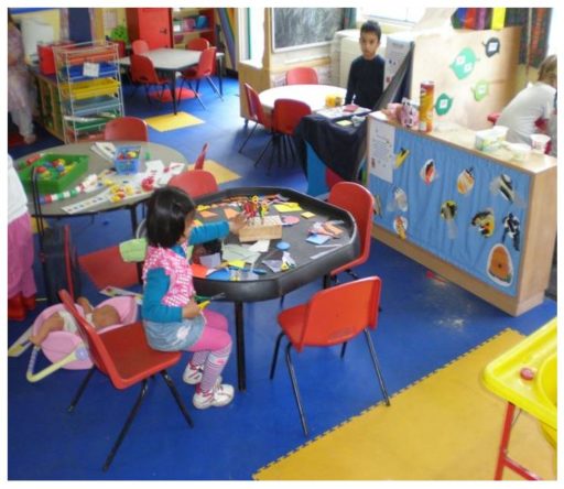 Auf diesem Bild sind zwei Kinder beim spielen auf einem blau gelben PVC Boden von FLOORWORK zu sehen.