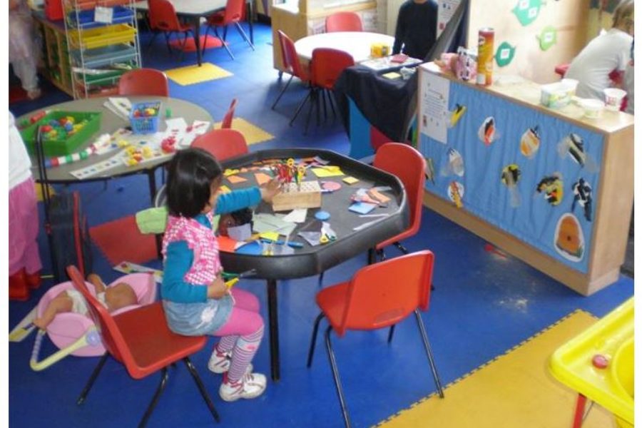 Auf diesem Bild sind zwei Kinder beim spielen auf einem blau gelben PVC Boden von FLOORWORK zu sehen.